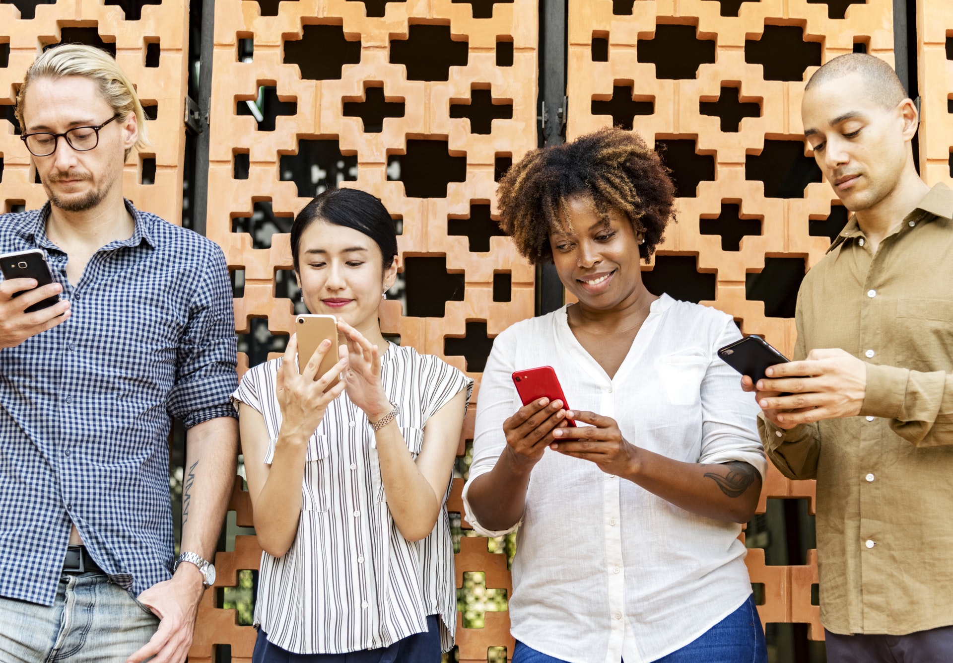 pexels-photo-1083622 Menschen vor Wand mit Smartphones in der Hand